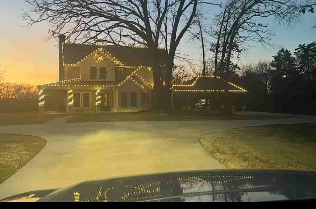 Decorative lighting along a large home and front driveway