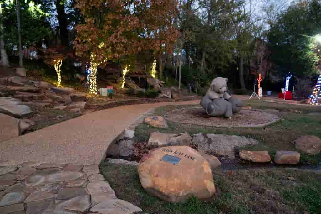 Stone path and landscaped park area decorated with warm lights